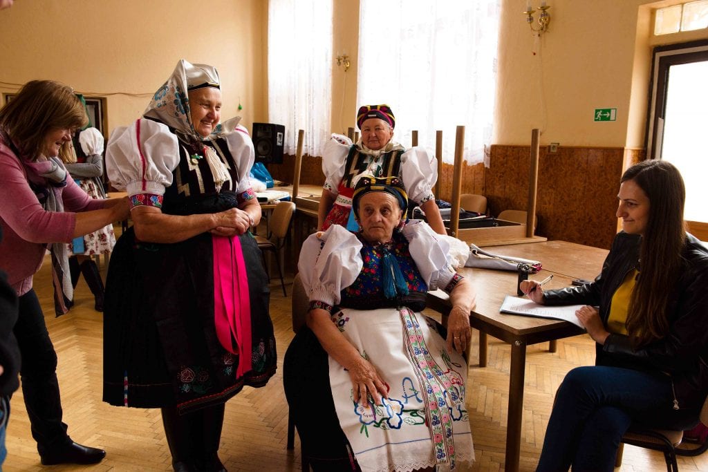 Tri krojované ženy sa za stolom rozprávajú s výskumníčkou.