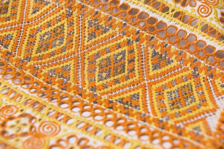 Detailný pohľad na rôznofarebné geometrické vzory, ktoré sú súčasťou čipky