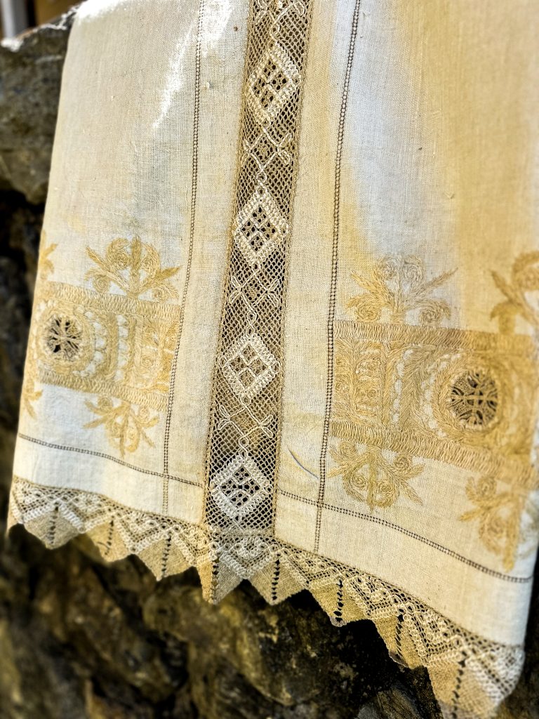 Zdobená visiaca bielo-žltá čipka.
